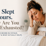 Woman sitting in bed looking fatigued beside an alarm clock displaying 8:00, with text reading “You Slept 8 Hours. Why Are You Still Exhausted? The science behind RA fatigue, poor sleep, and what actually helps.”